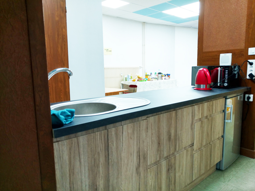 Salle E, l'ilot central de convivialité avec son réfrigérateur, micro-onde et bouilloire à équiper davantage selon convenance